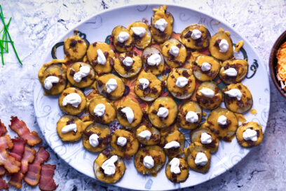 Loaded Baked Potato Bites on a counter with bacon and cheese on the sides