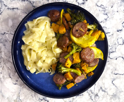 Sheet pan chicken sausage on a blue plate